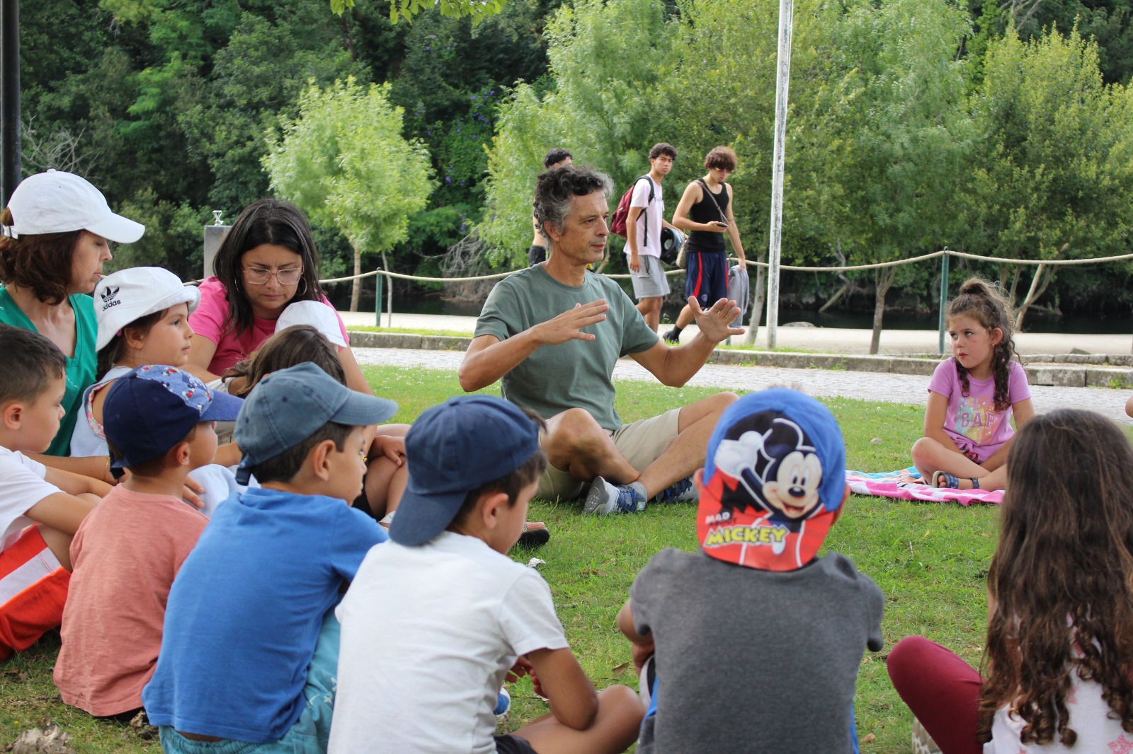 A trainer leading an empathy circle with children on the grass, image 4 of 13